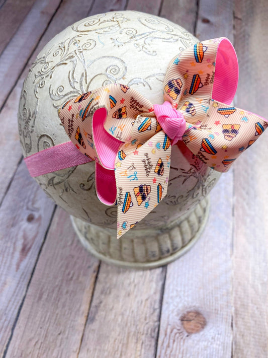 Decorative headband with colorful bow on a textured surface