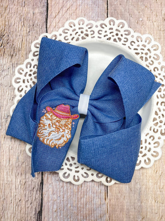 denim hair bow with a santa wearing a pink cowboy hat embroidery