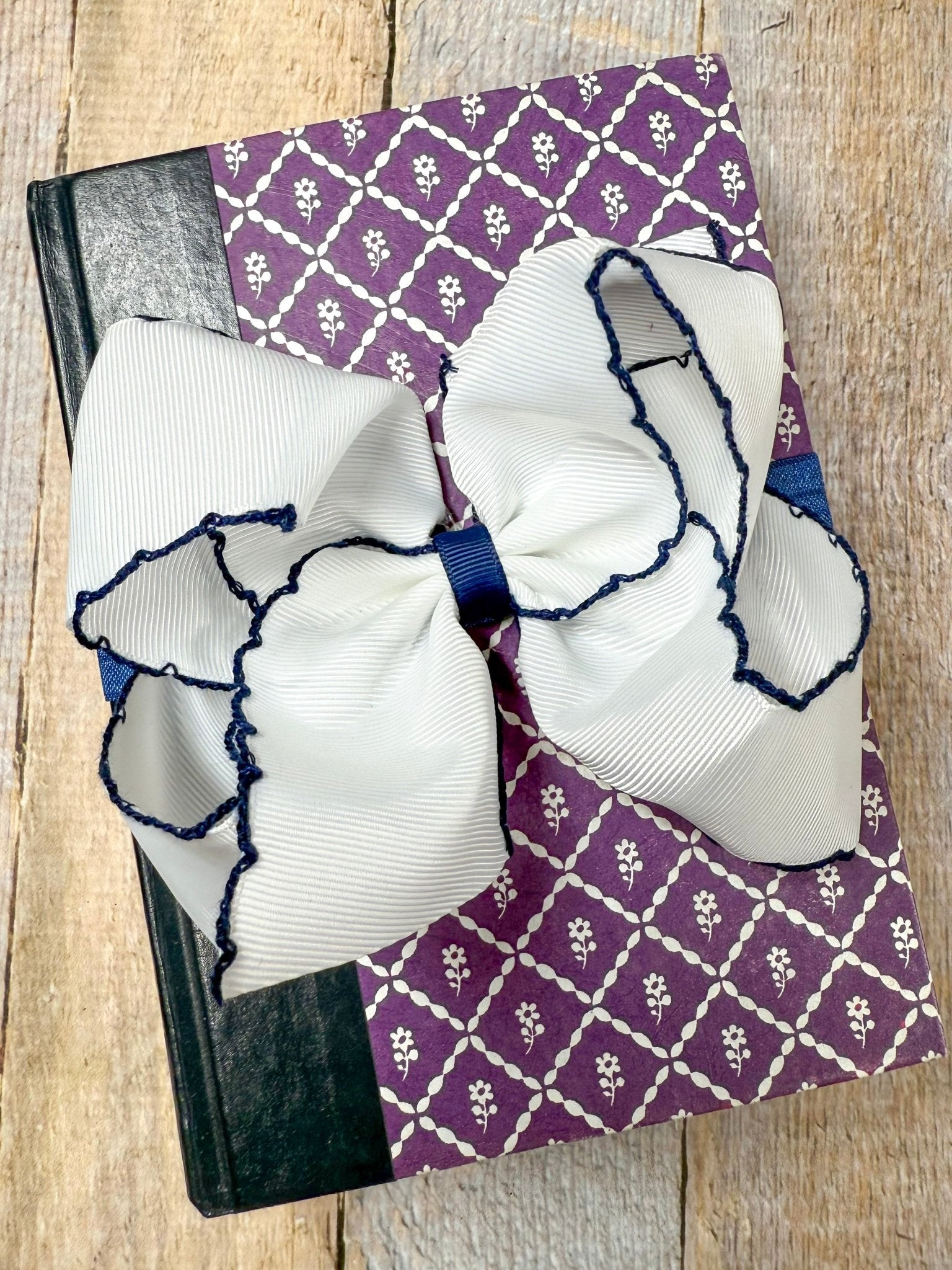 white and navy hair bow on headband on book display