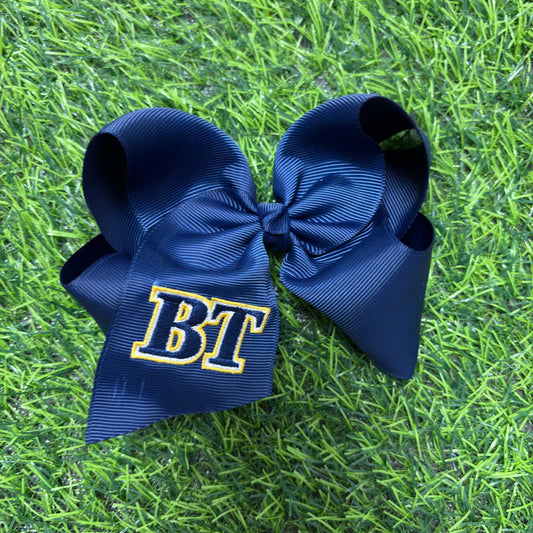 Two navy blue hair bows with 'BT' on a grass background - Alternative view