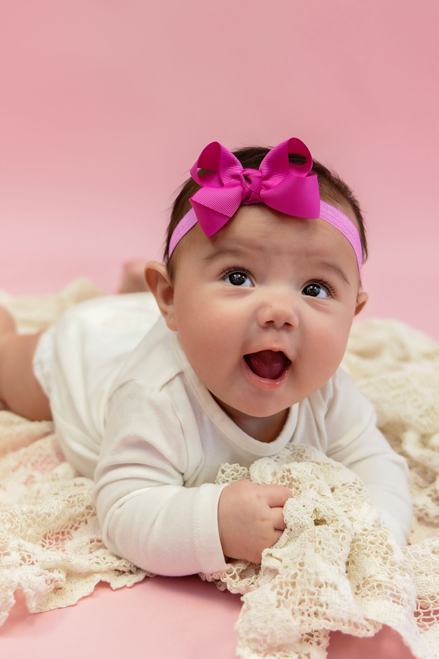 baby wearing bow headband in pink