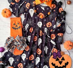 long sleeve dress with black background and ghosts pumpkins and spiderwebs all over dress. flat lay styled with decorative socks, bows, and various pumpkins
