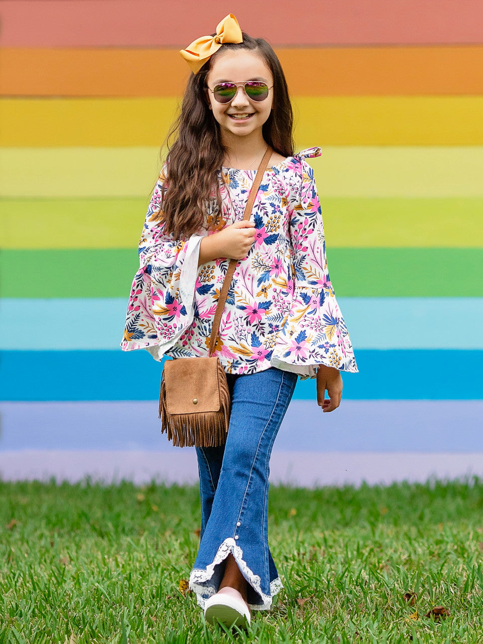Floral tunic shirt on a model standing in front of a colorful striped background.