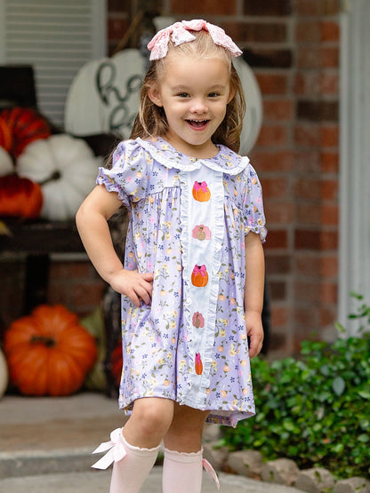Turkey & Pumpkin Embroidered Floral Dress on a little girl standing on a fall front porch.