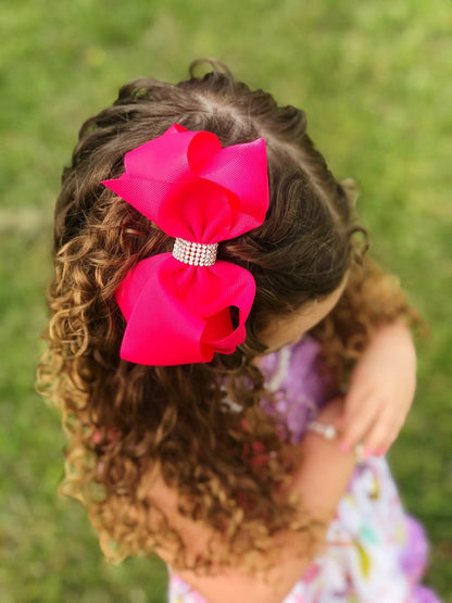Girl wearing a hot pink 4.5 inch classic rhinestone center hair bow