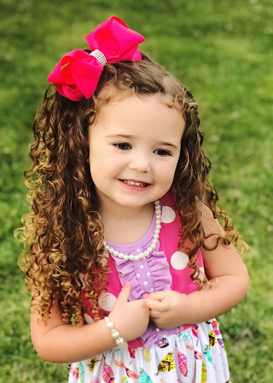 Girl wearing a hot pink 4.5 inch classic rhinestone center hair bow