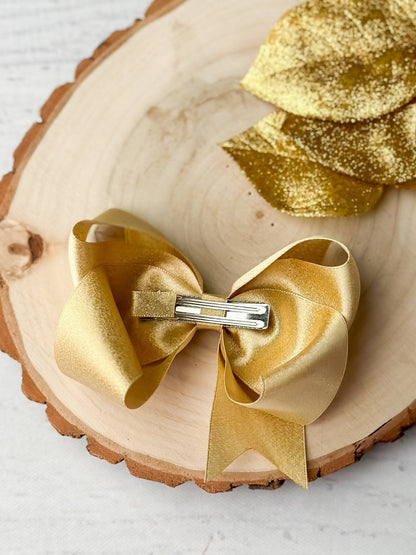 Back of 4.5 inch gold shimmer satin hair bow showing alligator clip