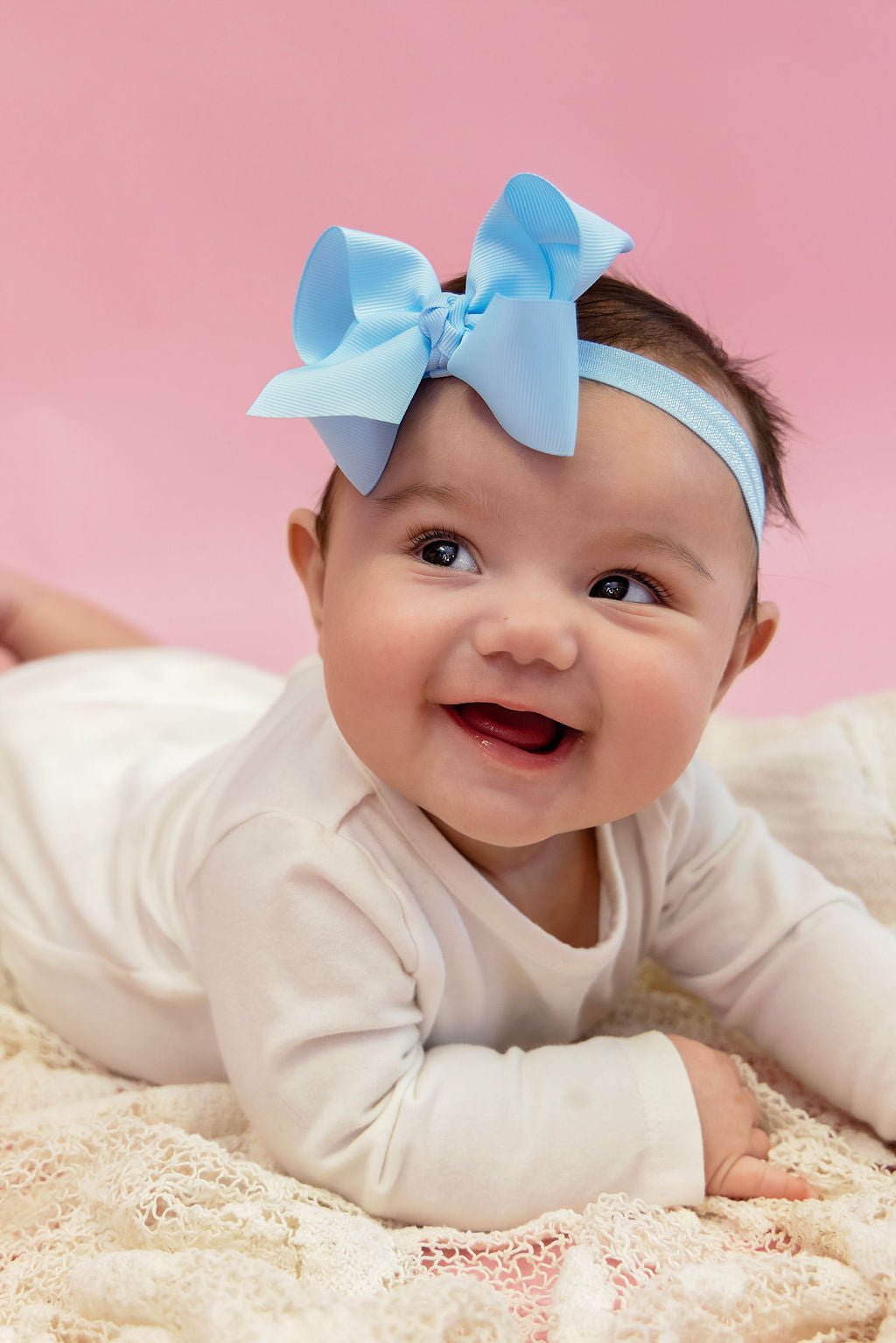 Baby girl wearing a 4 inch essential grosgrain hair bow on a satin headband