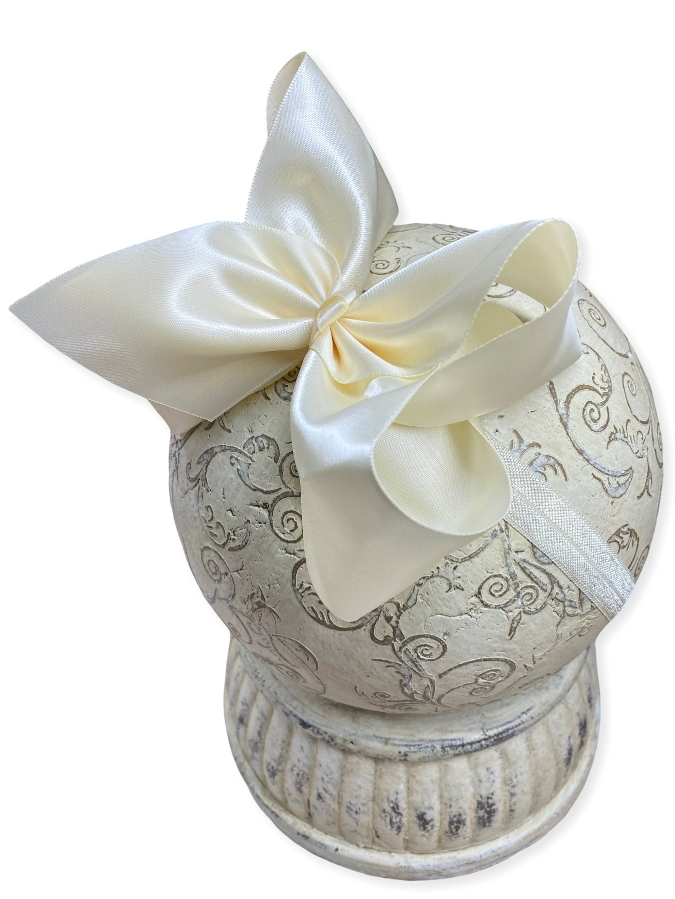Decorative urn with intricate patterns and a large cream-colored bow on a white background