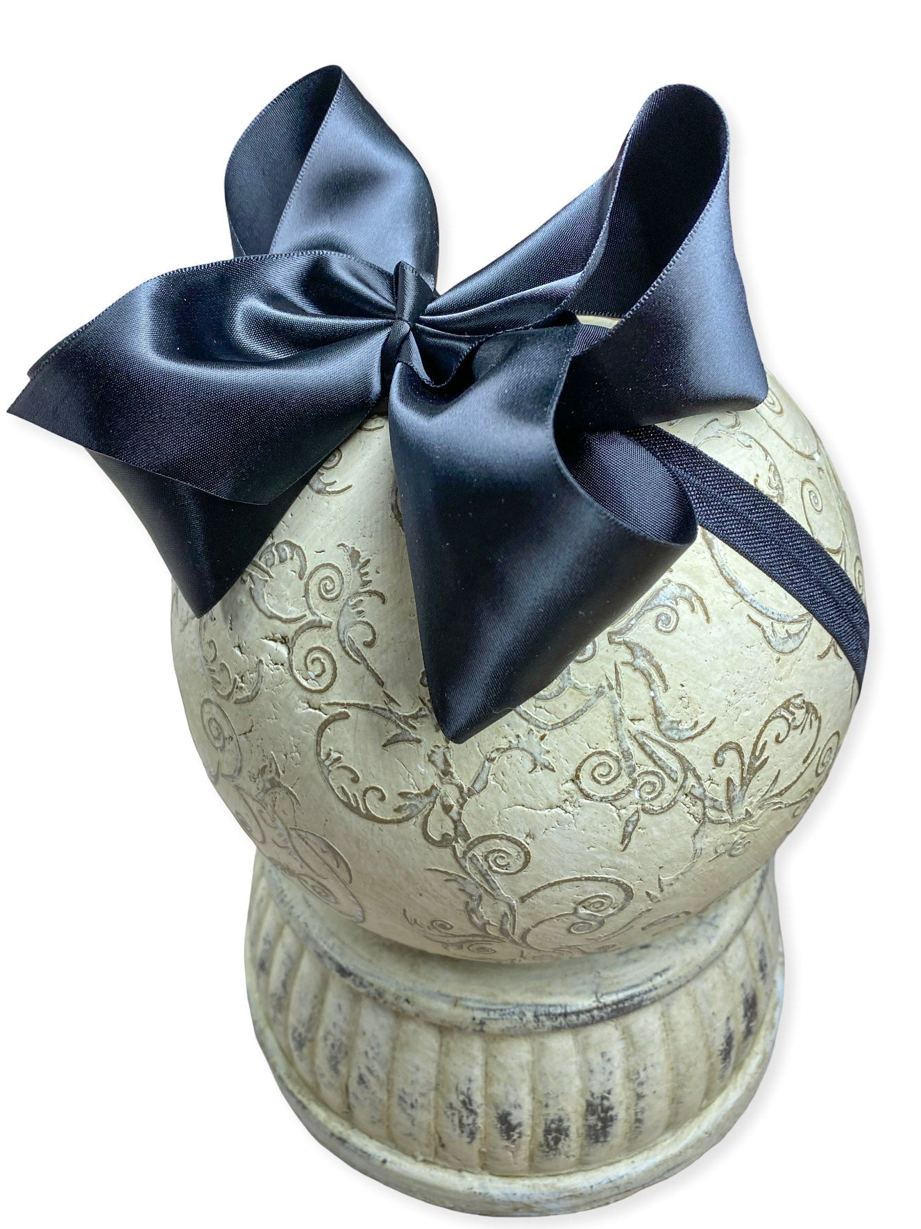 Decorative urn with a navy blue bow on a white background