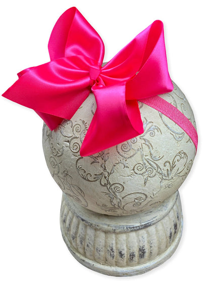 Decorative urn with a pink bow on a white background
