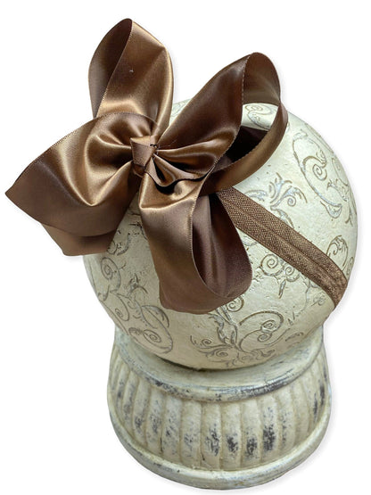 Decorative spool with a brown bow on a white background