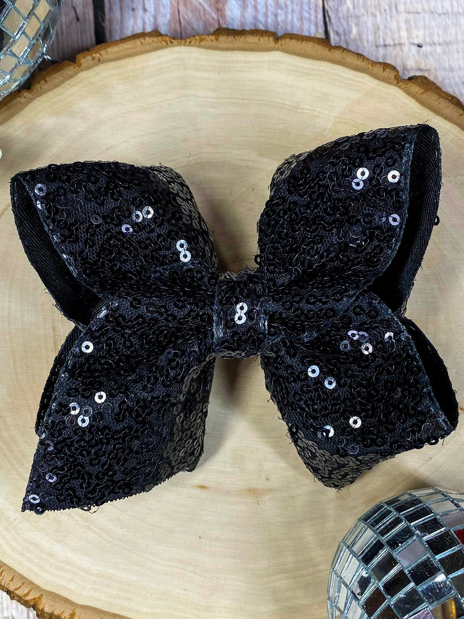 Black sequin bow on a wooden surface