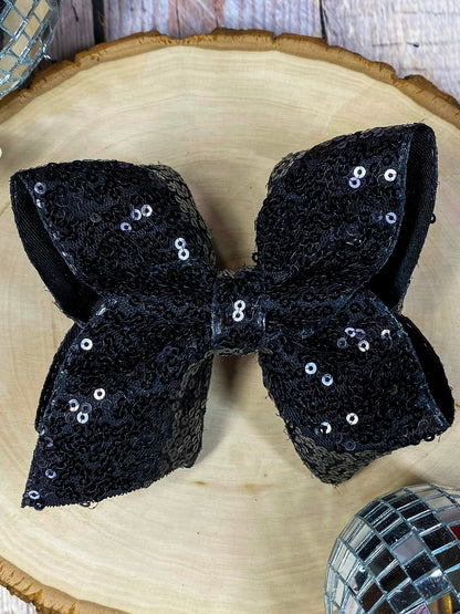 Black sequin bow on a wooden surface
