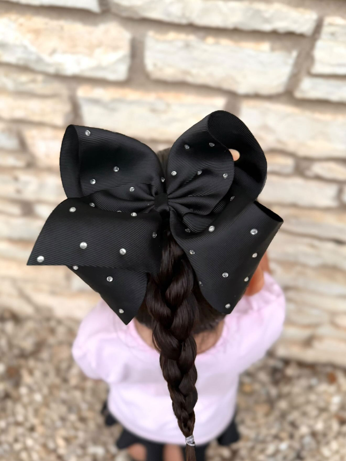 Girl wearing 5.5 inch black clear rhinestone hair bow