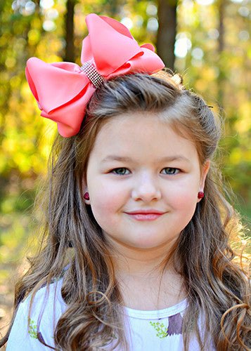 Girl wearing a 5.5 inch oversize rhinestone center knot hair bow