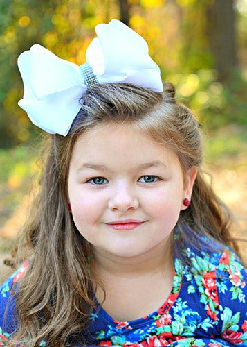 Girl wearing a 5.5 inch oversize rhinestone center knot hair bow