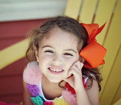 Girl wearing a 6.5 inch Texas size grosgrain hair bow