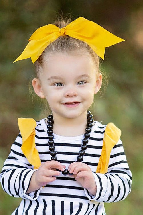 6 inch solid cheer bow worn on a high bun