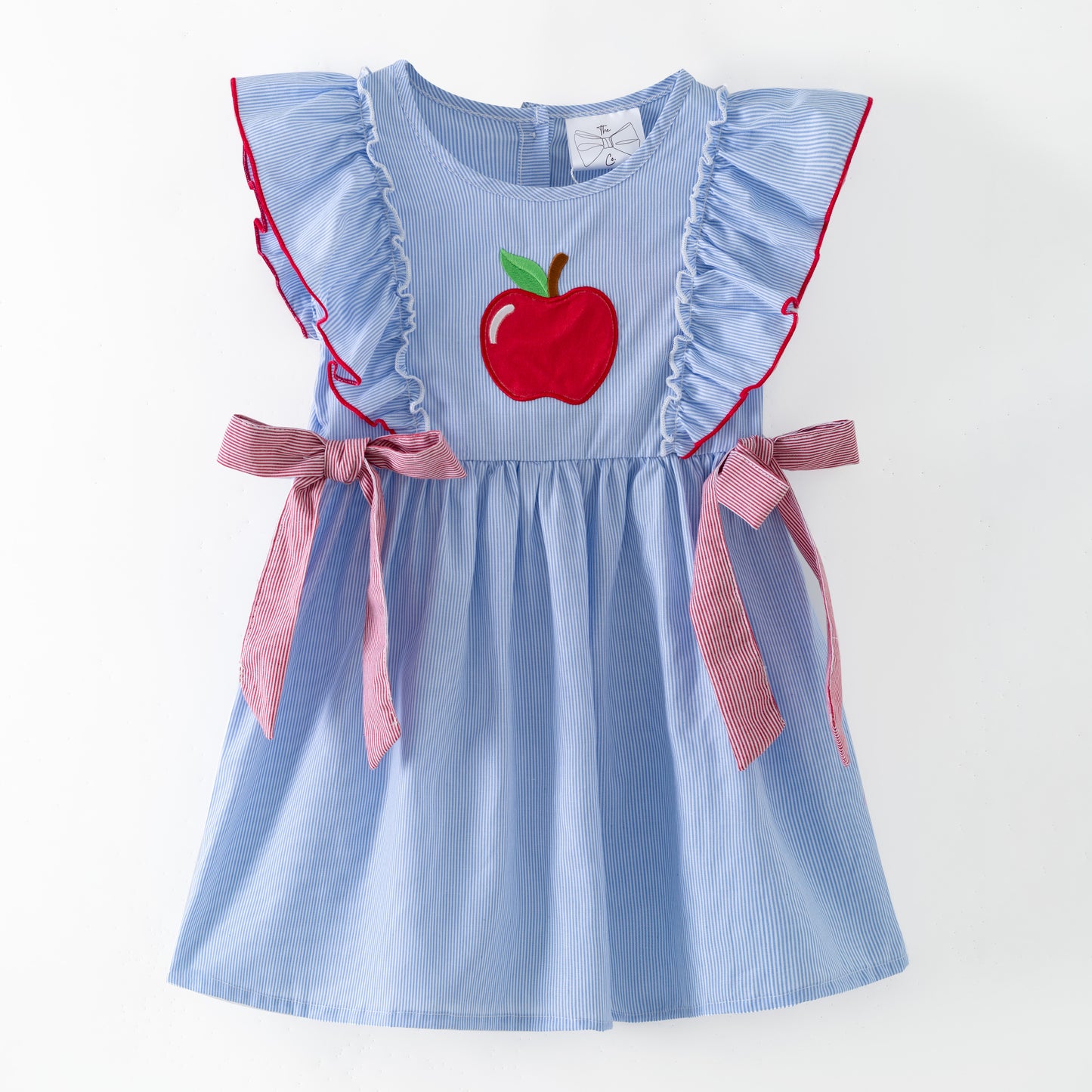 Blue dress with red apple design and pink accents on a white background
