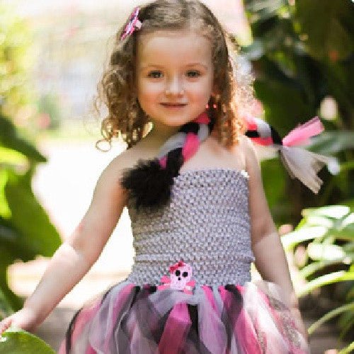 Young girl wearing a gray crochet tutu top with a pink, black, and white tulle skirt, accessorized with a matching braid scarf and hair clippie.
