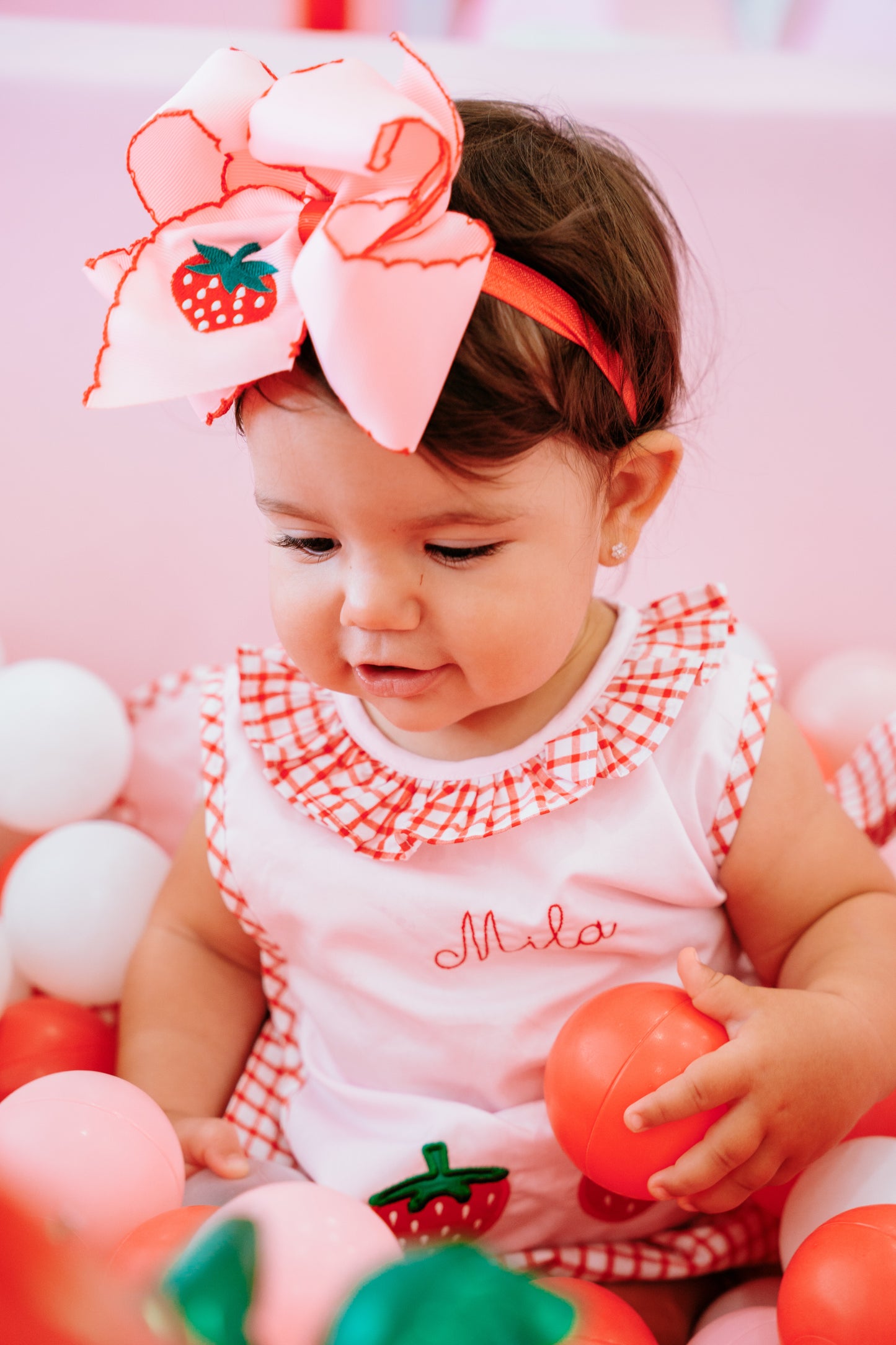 infant model wearing strawberry bow headband