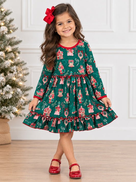 Girl wearing a Girls Vintage Christmas Print Ruffle Twirl Dress in green with festive holiday prints, red trim, and a ruffled hem, standing beside a Christmas tree.