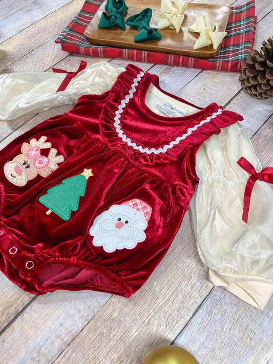 Detailed view of the romper made of rich red velvet, featuring a soft ruffle trim along the shoulders and neckline. A white scalloped ribbon detail outlines the ruffle, adding a playful, festive accent. - Alternative view