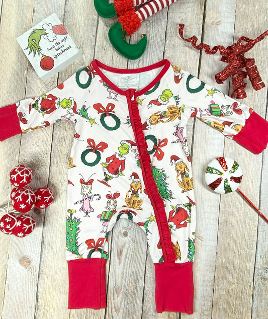 "Infant holiday romper with white fabric covered in playful Grinch characters, red bows, wreaths, and Christmas trees. Designed with vibrant red knit cuffs, a ruffled zipper front, and stretchy, soft material for cozy comfort."