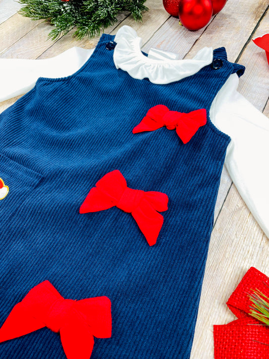 Close-up of bright red bows attached to navy blue corduroy fabric on girls’ holiday dress and infant romper, showcasing the vibrant color contrast and textured ribbon detail. - Alternative view
