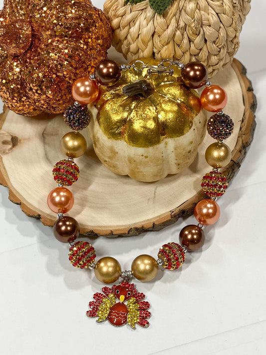 Featuring shimmer autumn color beads and a turkey pendant, these chunky bead necklaces will be perfect accessories for your little one's Thanksgiving outfits.