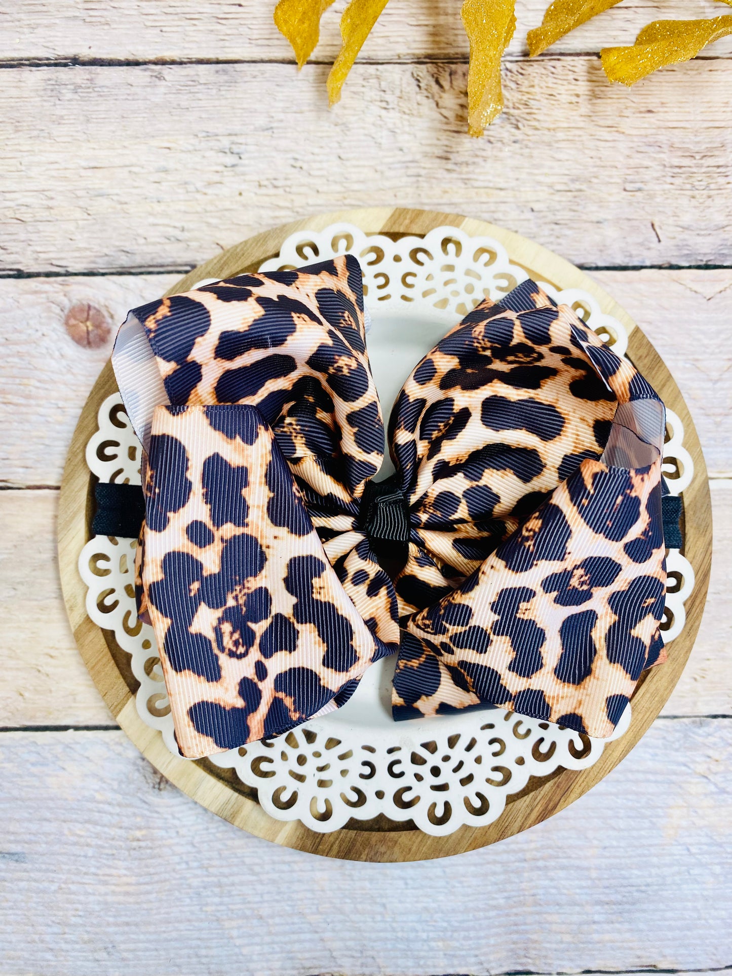 Leopard print headband on a decorative plate with a wooden background