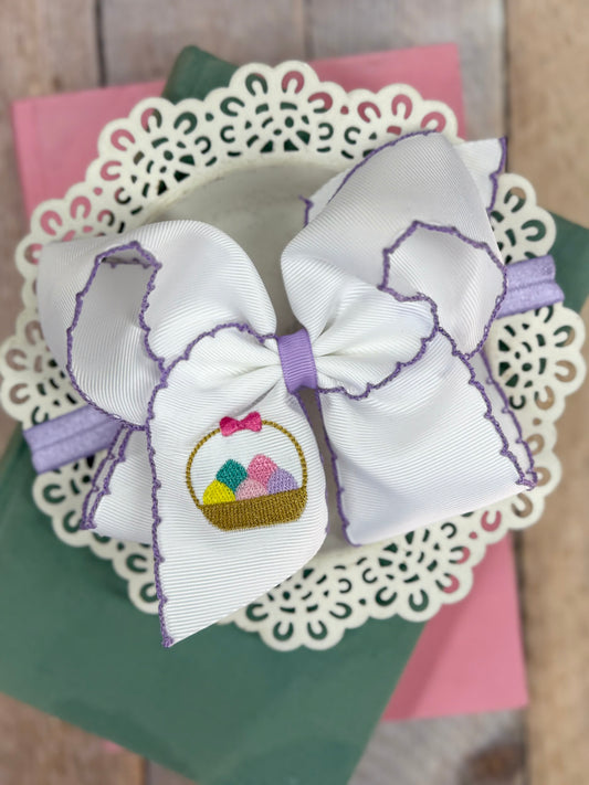 White Moonstitch headband with lavender edging and embroidered Easter egg basket on a soft nylon band