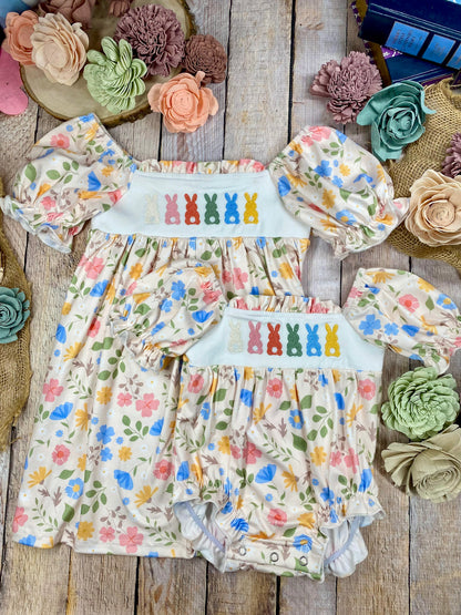 Children's floral outfit with matching headband on a wooden surface with decorative flowers.