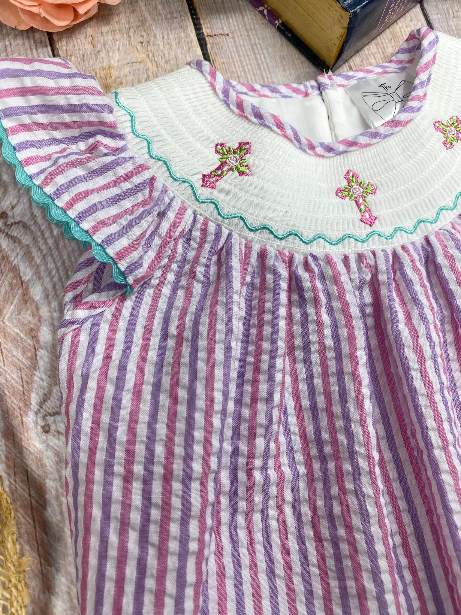 Striped dress with floral embroidery on a textured surface