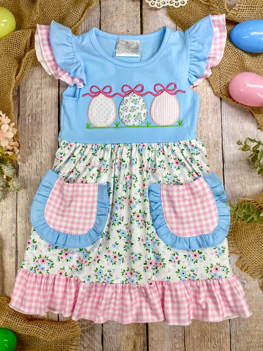 Children's dress with floral pattern and Easter design on a wooden surface