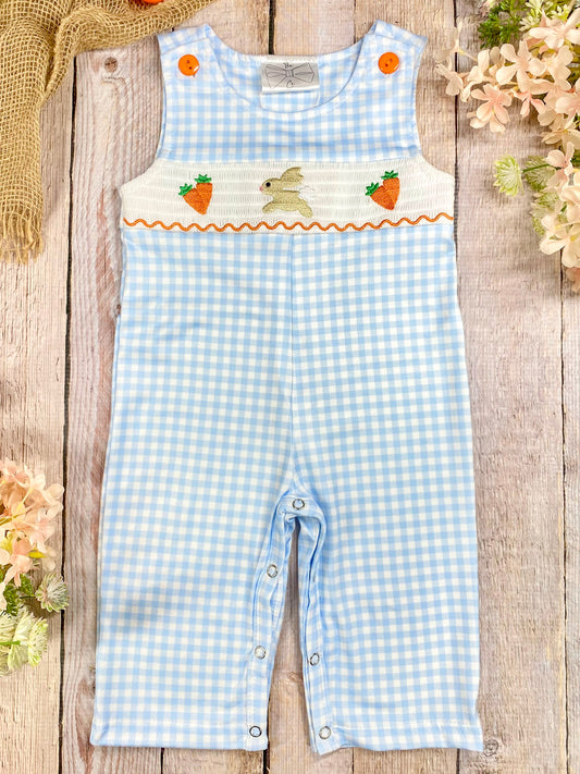 Blue gingham romper with bunny and carrot design on a wooden surface