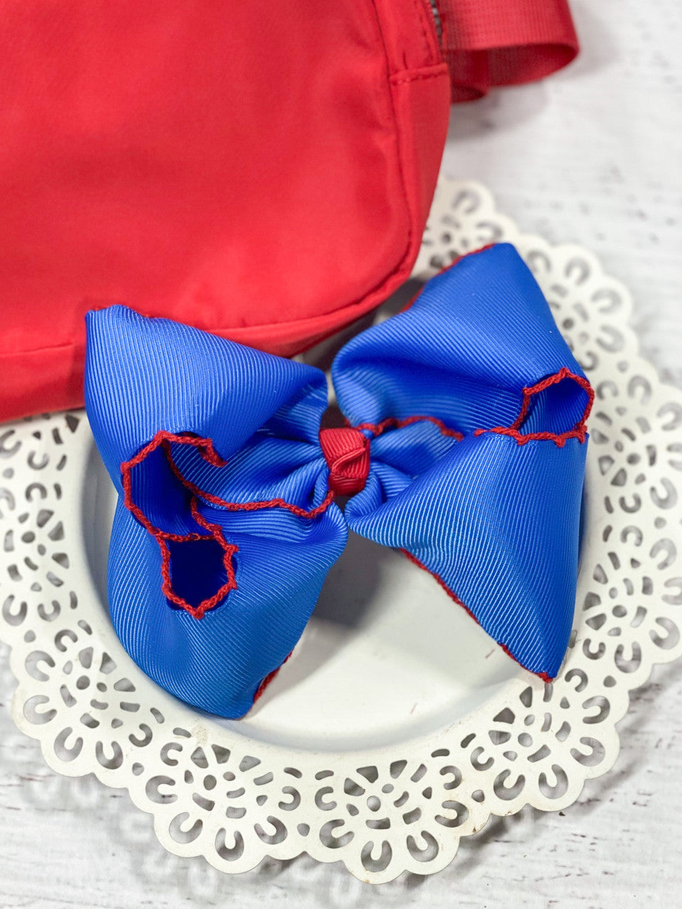 Our Royal Blue with Red Moonstitch hair bows is made with 2.25" ribbon and measure approximately 4-5 inches in width with contrast stitch edging. These big hair bows are perfect for your little girl. These bows include an alligator clip to securely attach to her hair.