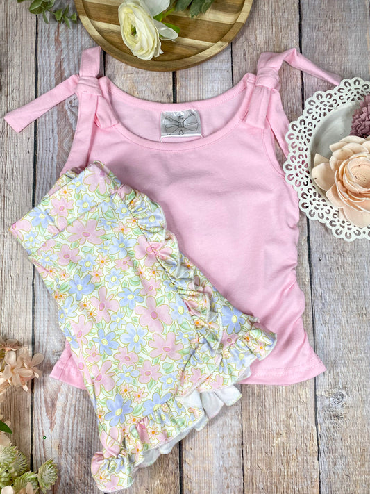 Pink top and floral shorts set on a wooden background