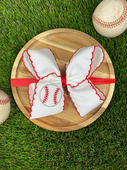 red and white baseball embroidered headband on a grass background