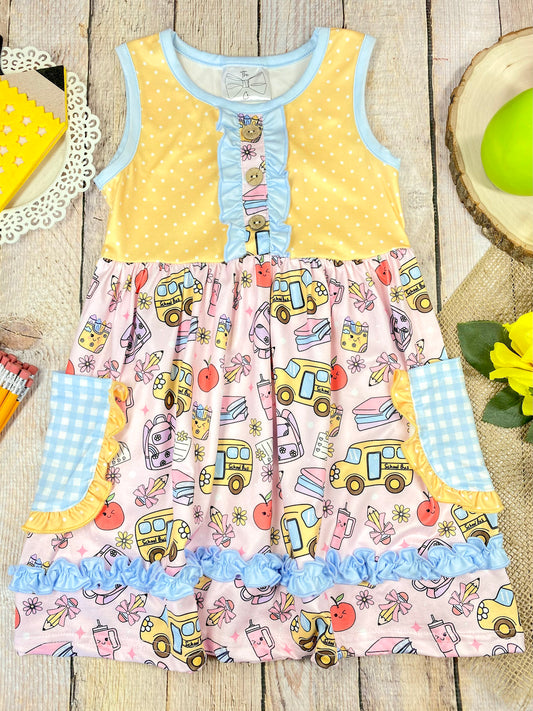 Colorful children's dress with cartoon bus and apple pattern on a wooden background - Alternative view