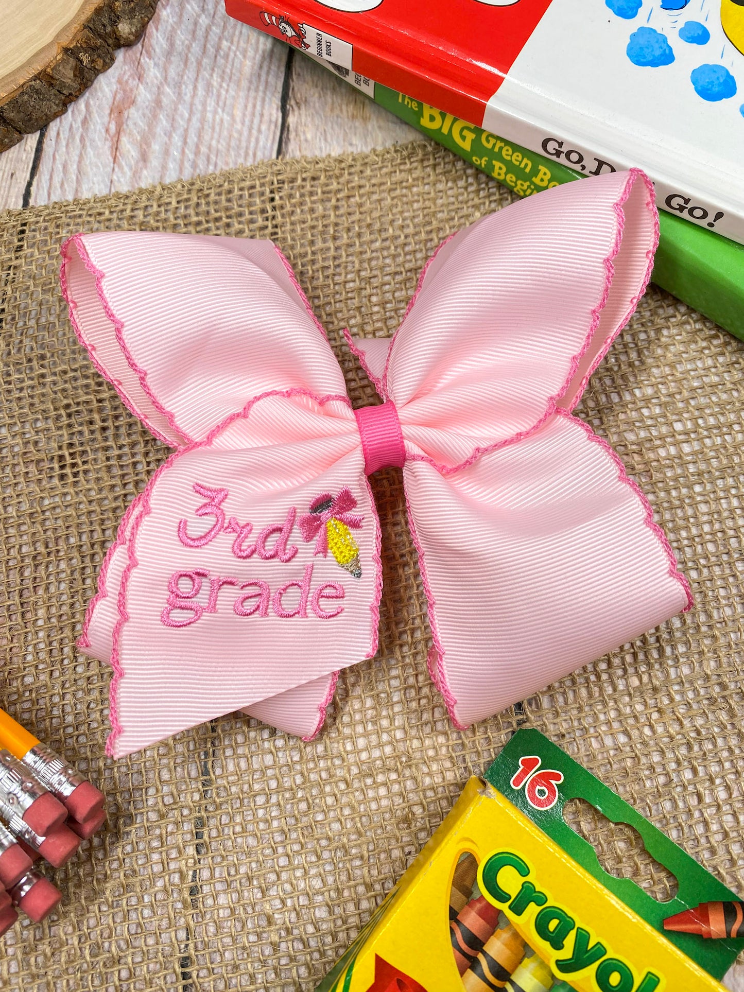 Pink School Grade Embroidered Cheer Bow on a wooden background
