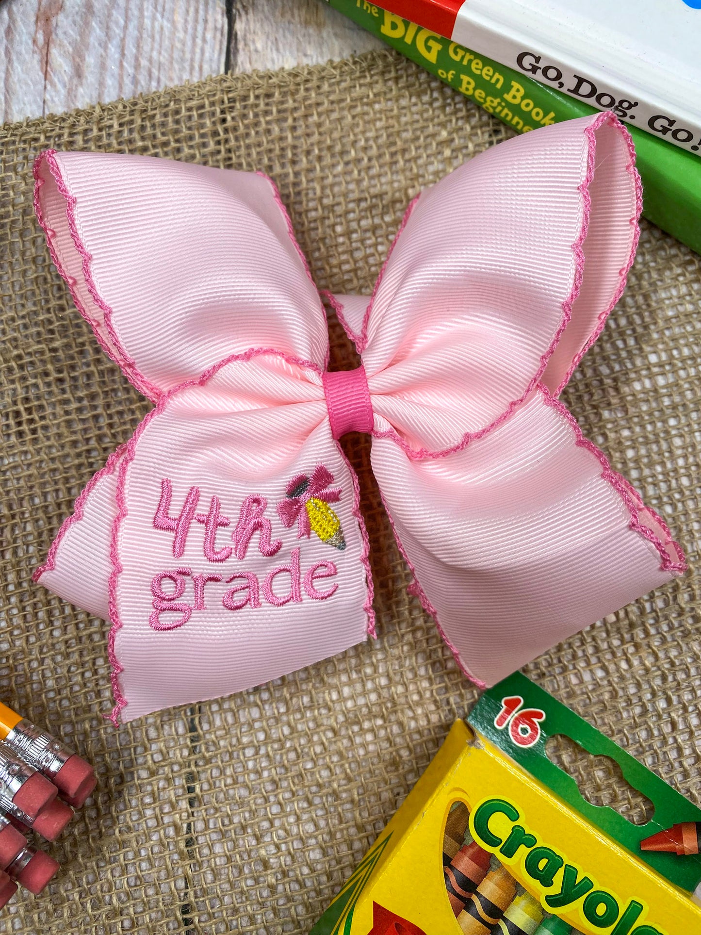 Pink School Grade Embroidered Cheer Bow on a wooden background