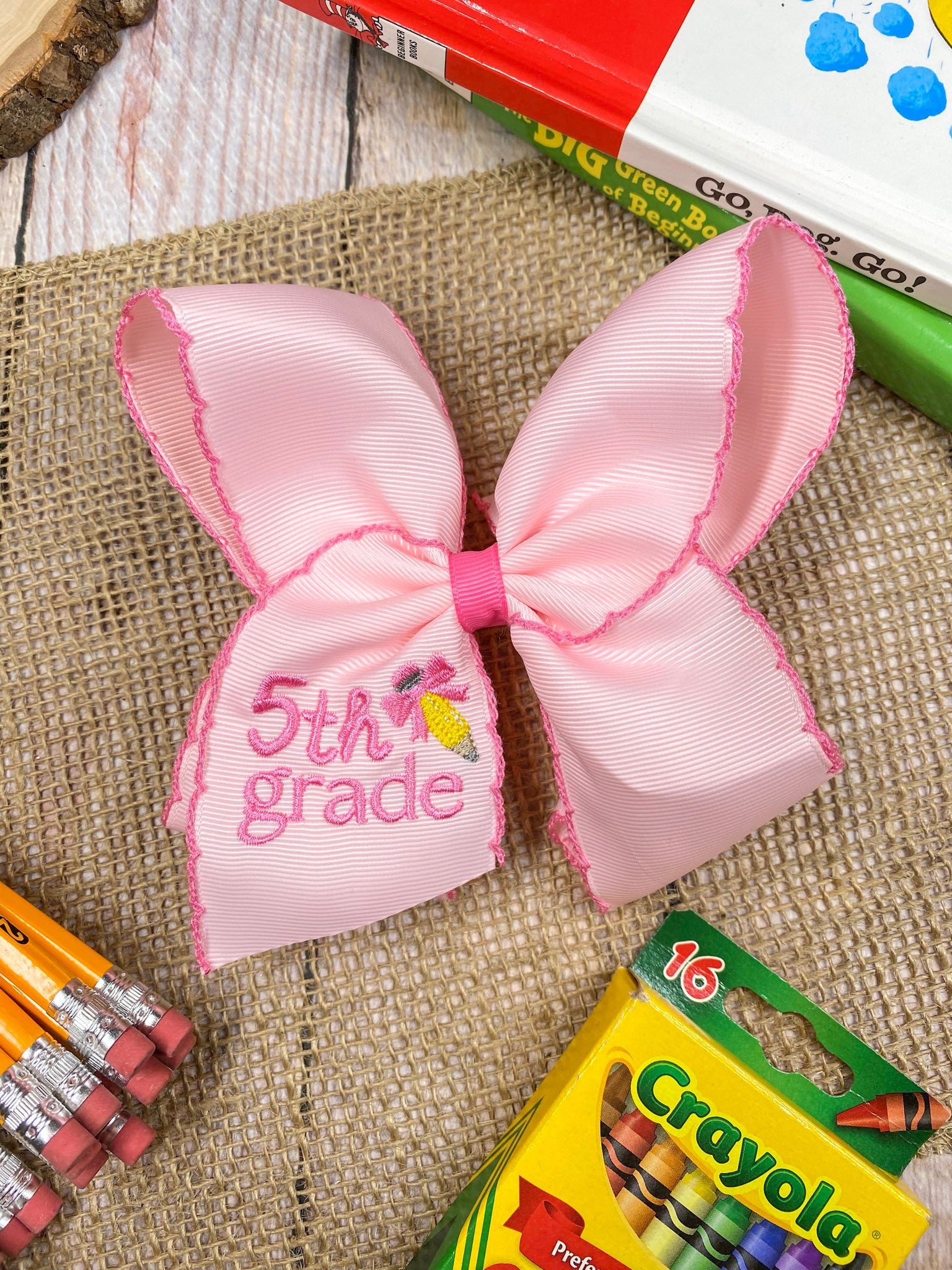 Pink School Grade Embroidered Cheer Bow on a wooden background