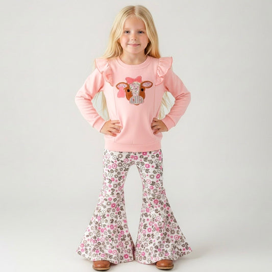 girl wearing a western two-piece with cow appliqué ruffle sweatshirt and pink floral bell bottoms