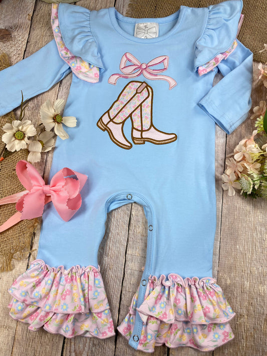 baby girl cowgirl one-piece with boots bow appliqué and floral ruffle leg hems on a wooden background - Alternative view