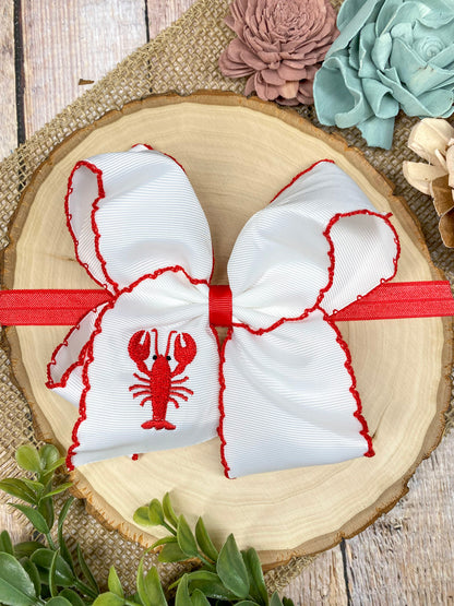 The Crawfish & Lobster Embroidered Moonstitch Headband on a wooden background