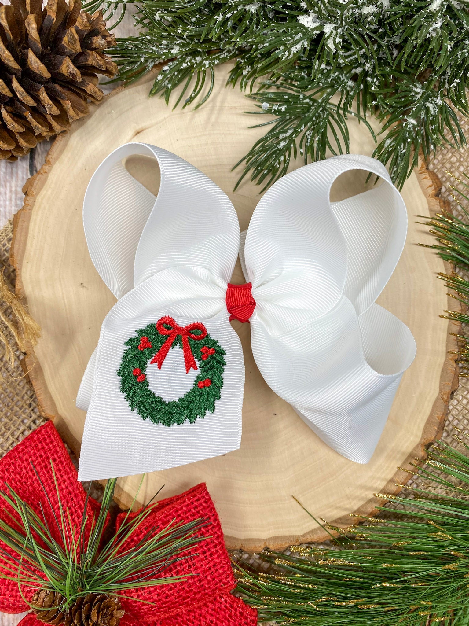 Wreath Embroidered Hair Bow on a wooden background