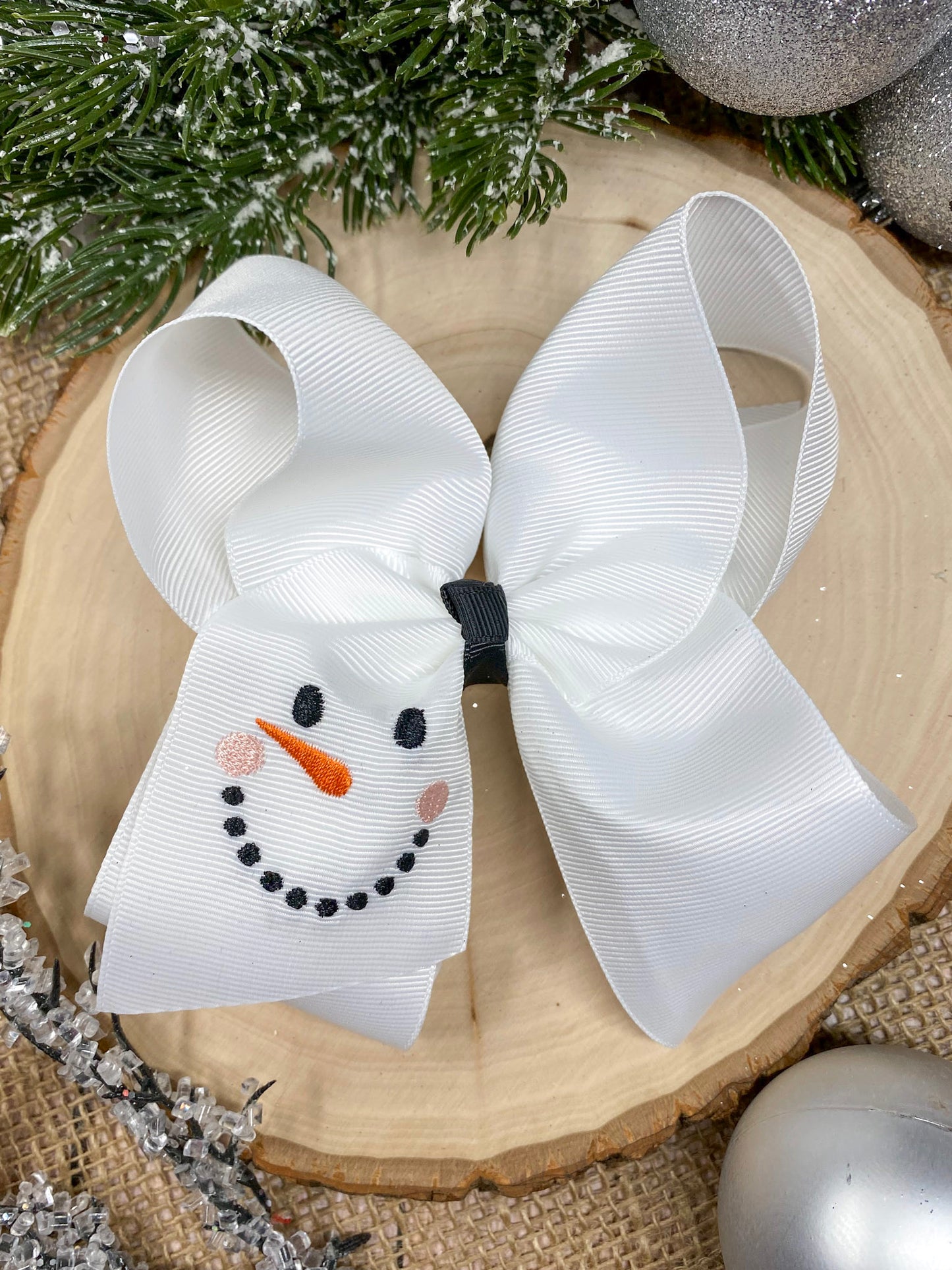 White Snowman Embroidered Bow on a wooden background