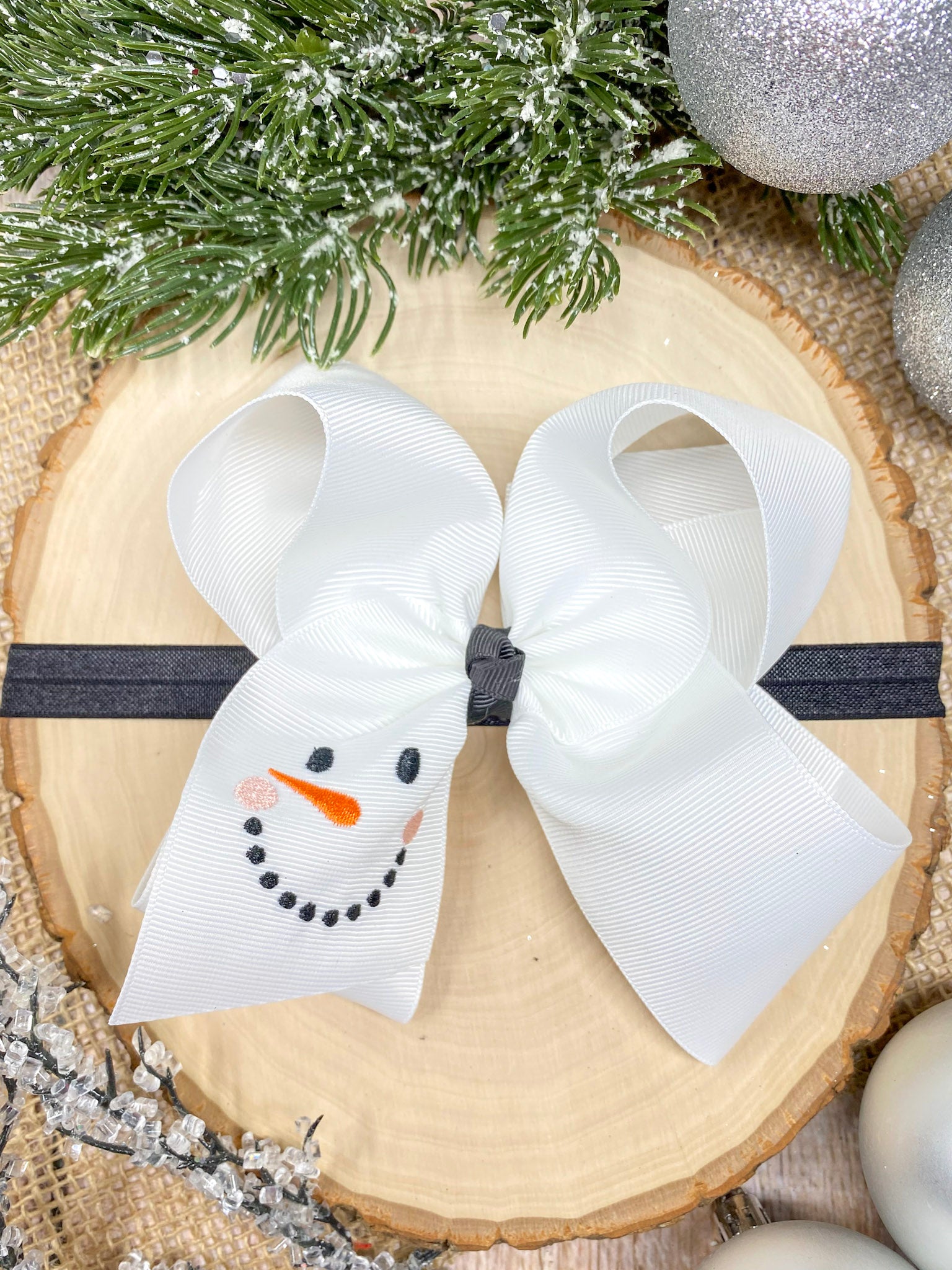 White Snowman Embroidered Headband on a wooden background